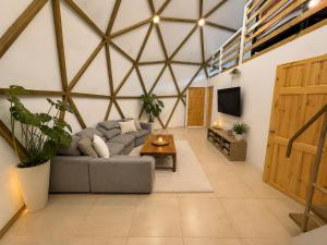 a living room with a gray couch and a table at Kayala Domes - Unique Luxury Domes in the Mountains - 4x4 recommended in La Ese