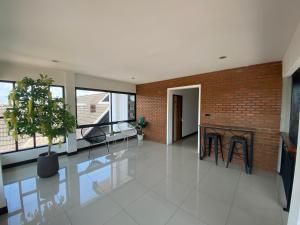 a living room with a fireplace and a brick wall at The Connect Chiang Mai in Chiang Mai