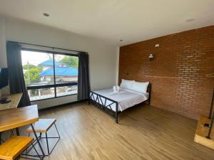 a room with a bed and a brick wall at The Connect Chiang Mai in Chiang Mai