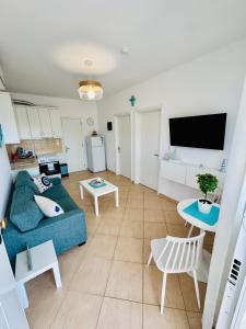 a living room with a blue couch and a table at MG Sea View Apartments & Private Parking in Pefkochori