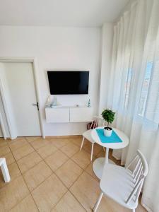 a living room with a tv and a table and chairs at MG Sea View Apartments & Private Parking in Pefkochori +78 photos