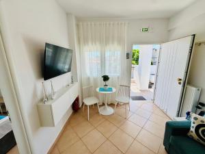 a living room with a table and a tv at MG Sea View Apartments & Private Parking in Pefkochori