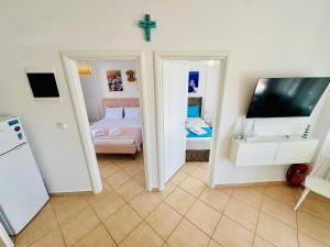 a room with a bedroom with a bed and a tv at MG Sea View Apartments & Private Parking in Pefkochori
