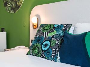 a bed with two pillows on top of it at Ibis Styles Cayenne Centre Amazonia in Cayenne
