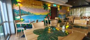 a dining room with a table and a painting on the wall at Noa Hotel in Auckland