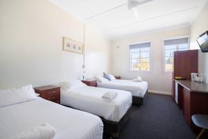 a hotel room with two beds and a television at Knickerbocker Hotel in Bathurst