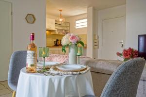 a table with a bottle of wine and a glass at Nid rose paradis secret au robert avec jacuzzi in Le Robert