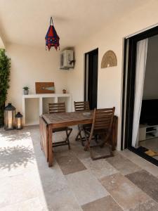 a dining room with a wooden table and chairs at La cigale bleue - Garden level in Sanary-sur-Mer +6 photos