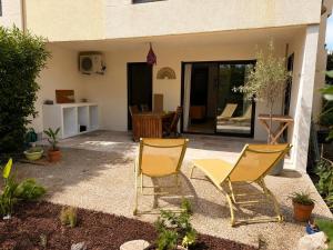 two chairs and a table in front of a house at La cigale bleue - Garden level in Sanary-sur-Mer