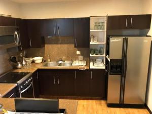 a kitchen with black cabinets and a stainless steel refrigerator at Edificio San Antonio in Monterrey