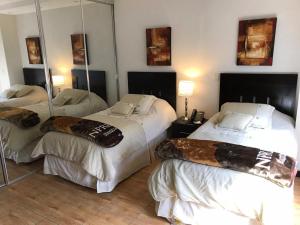 a hotel room with three beds and a mirror at Edificio San Antonio in Monterrey