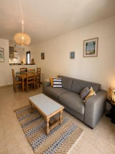 a living room with a couch and a table at La cigale bleue - Garden level in Sanary-sur-Mer