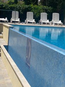 a swimming pool with lawn chairs and a row at Adriadome Sky in Bijela
