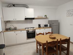 a kitchen with white cabinets and a table with chairs at Casa Atalaya en Malpica in Malpica