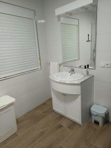 a white bathroom with a sink and a mirror at Casa Atalaya en Malpica in Malpica