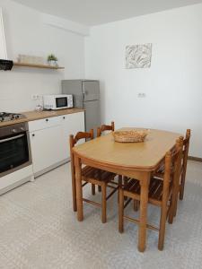 a kitchen with a wooden table and chairs in it at Casa Atalaya en Malpica in Malpica +4 photos