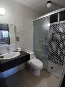 a bathroom with a toilet and a sink and a shower at Hotel Santa María in Mazatlán +6 photos