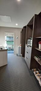 a kitchen with wooden cabinets and a microwave at Hidden Gem in Oaklands in Napier +23 photos