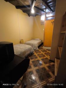 a room with two beds and a tv in it at Casa de Turistas La Rinconada in Chacas
