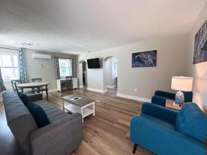 a living room with two blue couches and a table at Sails Resort Motel in St. Pete Beach