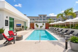 an image of a pool with lounge chairs and a building at Splendid Executive Suites in Long Beach