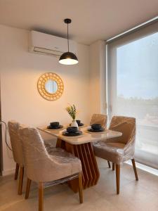 a dining room with a table and chairs and a mirror at Feel Premiun 2408 in Asunción