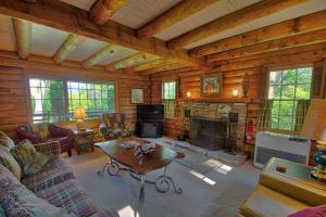 a living room with a fireplace in a log cabin at Winds Aloft in Newland