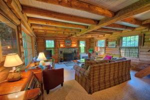 a living room with couches and a fireplace in a cabin at Winds Aloft in Newland