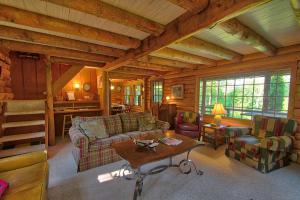 a living room with couches and a table in a cabin at Winds Aloft in Newland