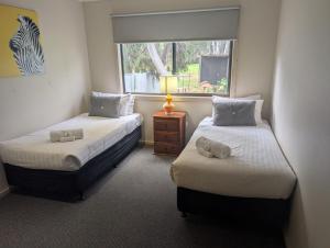 two beds in a room with a window at Riverside Golf Club in Gol Gol