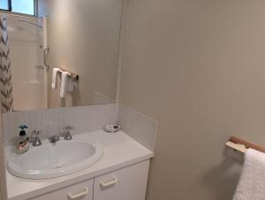 a white bathroom with a sink and a mirror at Riverside Golf Club in Gol Gol
