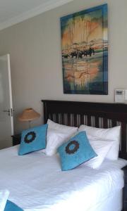 Una cama con dos almohadas azules encima. en Eden Cottage en White River
