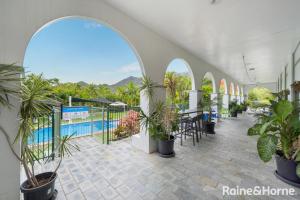 a building with a pool and a patio with plants at 71 Mandalay in Nelly Bay