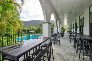 a patio with tables and chairs and a swimming pool at 71 Mandalay in Nelly Bay