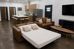 a living room with a couch and chairs and a kitchen at Glacier Luxury Retreat Oak Tree Apartment 3 in Hungry Horse