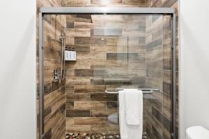 a shower in a bathroom with wooden tiles at Glacier Luxury Retreat Oak Tree Apartment 3 in Hungry Horse +22 photos