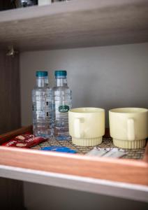 a shelf with bottles of water and bowls on it at استديو خاص in Al Khobar