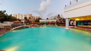 a large pool of blue water next to a building at Beachfront Getaway Condo in Cancún