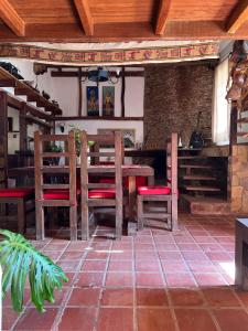 a restaurant with a wooden table and red chairs at Casa Alquimia Completa in Samaipata