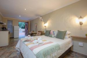 a bedroom with a large bed with two stuffed animals on it at Baobab at 36 Rissik in Komatipoort +16 photos