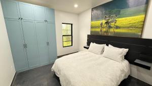 a bedroom with a bed and a painting on the wall at Glacier Luxury Retreat Montana Sky Apartment 2 in Hungry Horse