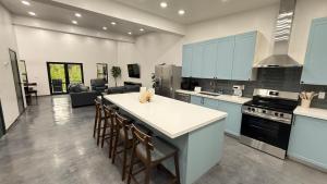 a kitchen with blue cabinets and a kitchen island with chairs at Glacier Luxury Retreat Montana Sky Apartment 2 in Hungry Horse
