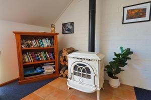 a room with a stove and a book shelf at Girraween Country Inn in Ballandean