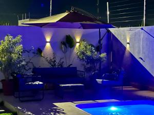 a patio with an umbrella and a pool at night at casa com piscina in Sinop
