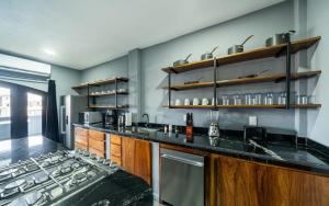 a kitchen with black counter tops and wooden cabinets at Casa Del Toro in Barra de Navidad