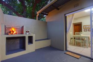 a living room with a fireplace and a patio at Baobab at 36 Rissik in Komatipoort