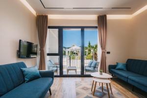 a living room with two blue couches and a balcony at Apartments Stanaj in Ulcinj