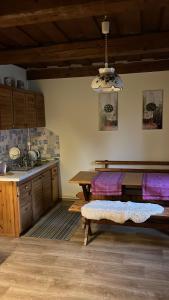a kitchen with a table and a bench in a room at Pokój i Spokój in Szarki