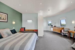 a bedroom with a large bed and a desk at Headlands Hotel in Opunake
