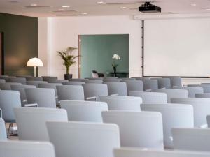 an empty room with white chairs and a screen at Mercure Maintenon in Maintenon +45 photos